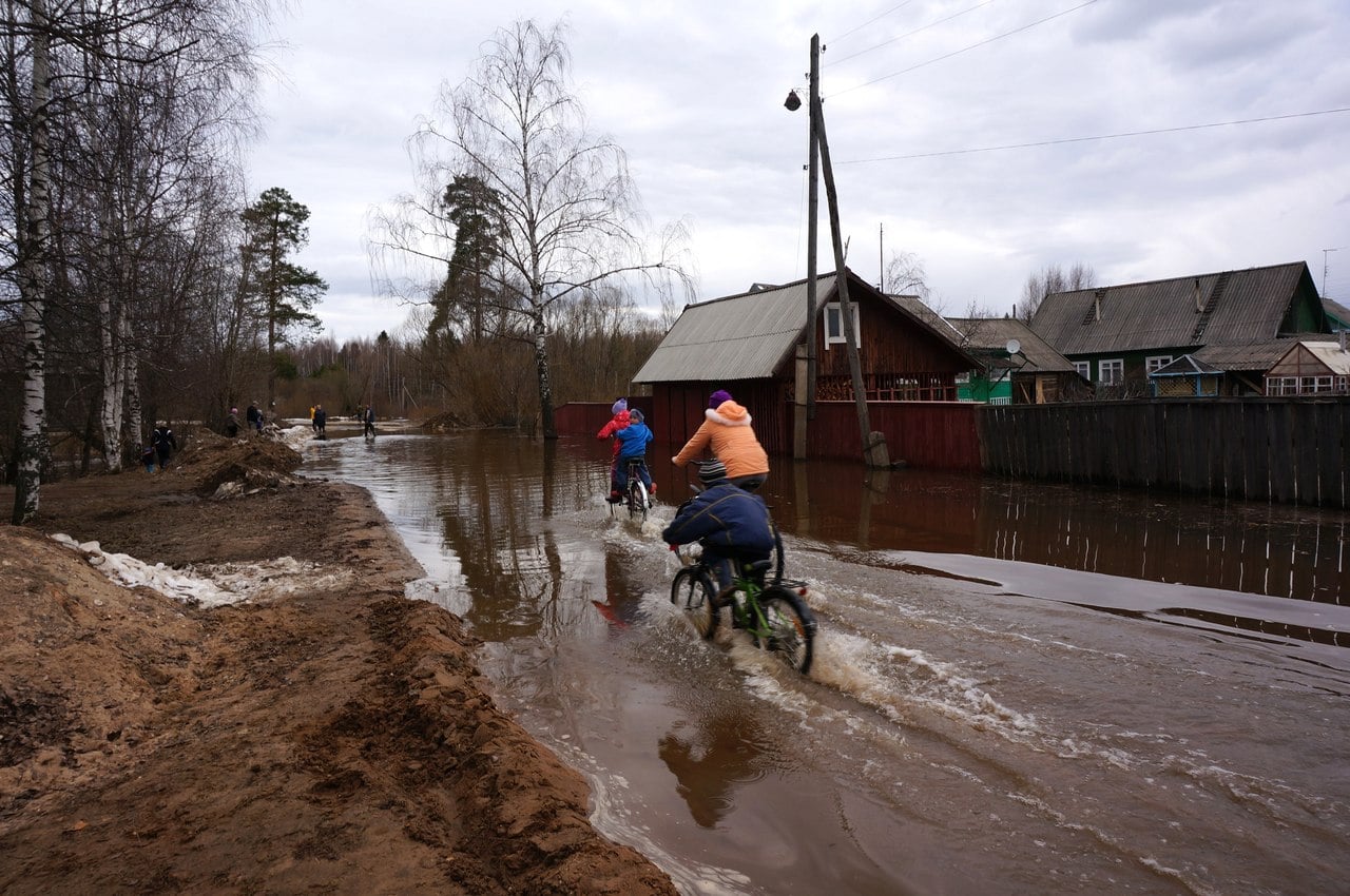 Дети катаются на велосипедах по затопленной улице братьев Даниловых